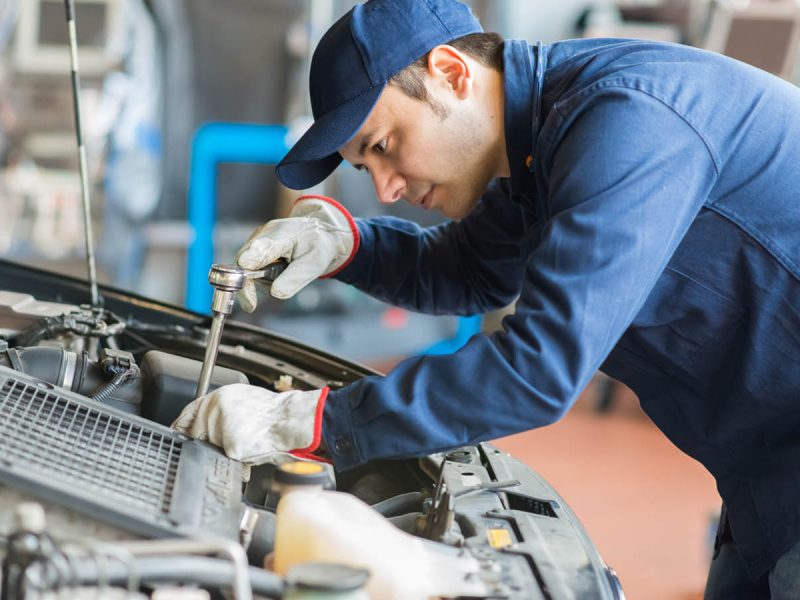 Auto mechanic working on a car in his garage Auto mechanic working on a car in his garage