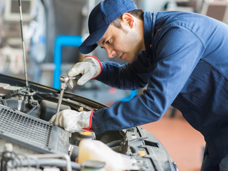 Auto mechanic working on a car in his garage